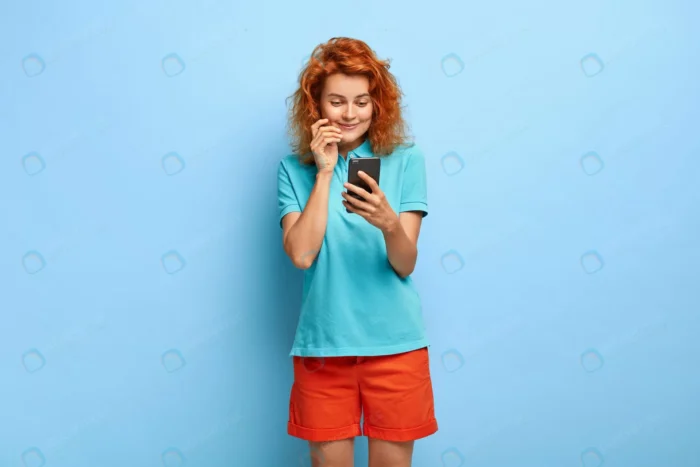 photo attractive millennial girl with ginger hair crc1384b764 - title:دختر مو قرمزی در حال نگاه کردن به موبایل - اورچین فایل - format:JPG - استوک - sku:crc1384b764 - keywords: p_id:90719