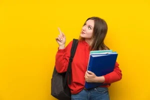 teenager student girl yellow wall pointing with index finger great idea - title:Home - اورچین فایل - format: - sku: - keywords: p_id:18